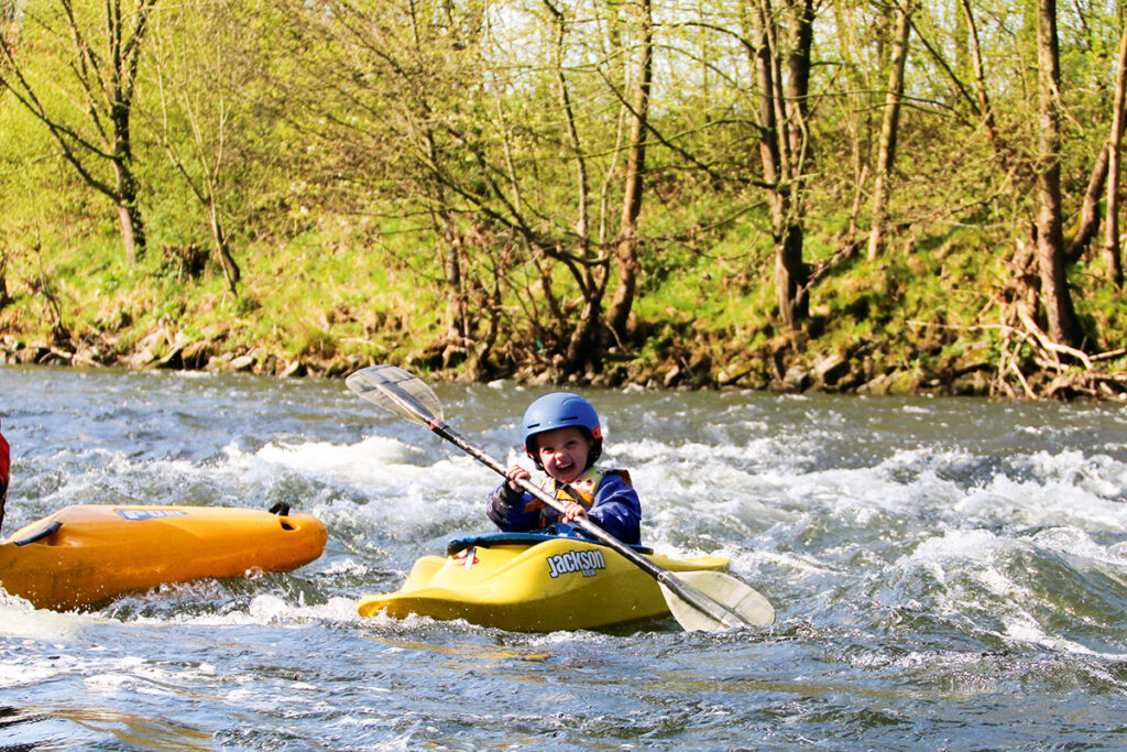 Kinder paddeln im Wildwasser