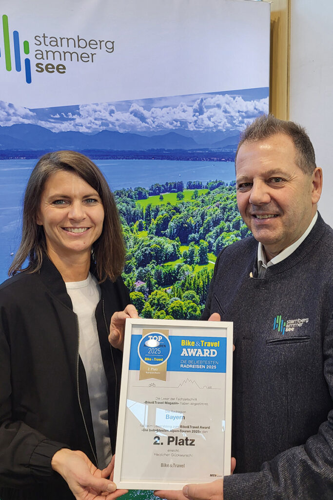 Werner Schmid, Geschäftsführer der gwt Starnberg GmbH, nimmt von Tanja Willmann (MSV Medien Baden-Baden) die Urkunde für den 2. Platz für die »Radregion Bayern« in der Kategorie »Beliebteste Alpentouren« entgegen.