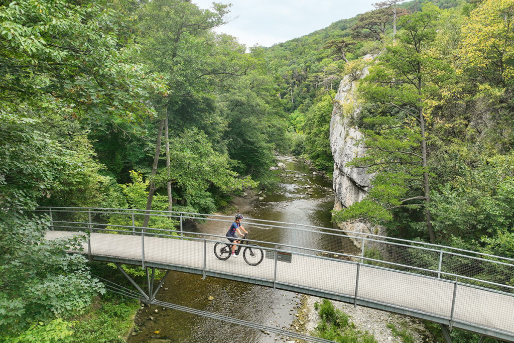 Radfahrerin auf einer Brücke auf der Klöster Kaiser Künstler Tour