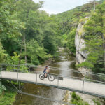 Radfahrerin auf einer Brücke auf der Klöster Kaiser Künstler Tour