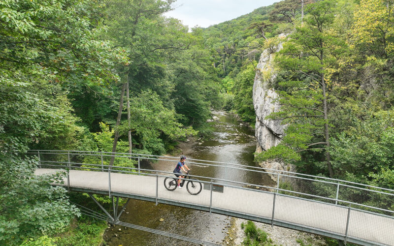 Radfahrerin auf einer Brücke auf der Klöster Kaiser Künstler Tour